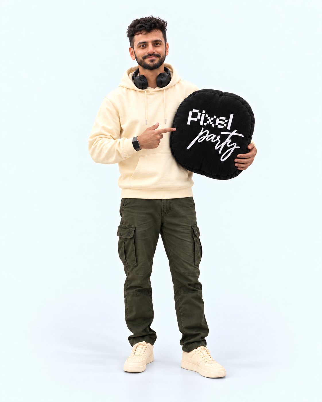 Harish holding a round black Pixel Party cushion and pointing at it
